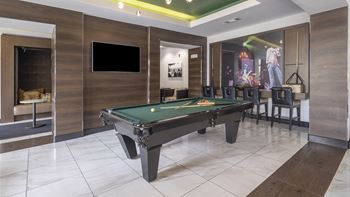 A billiards table in a game room with a tv